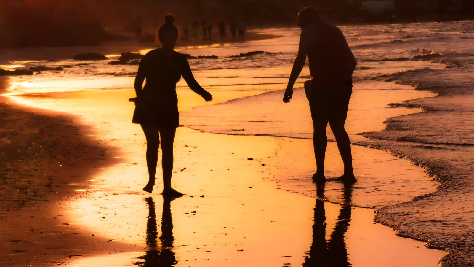 Siluete para na plaži u zalazak sunca