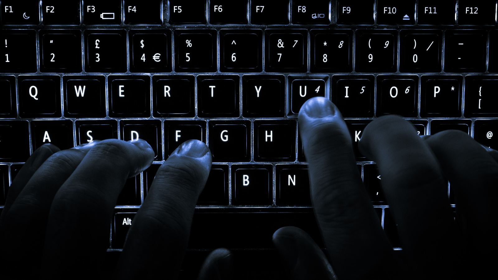 Ruke na osvetljenoj tastaturi
