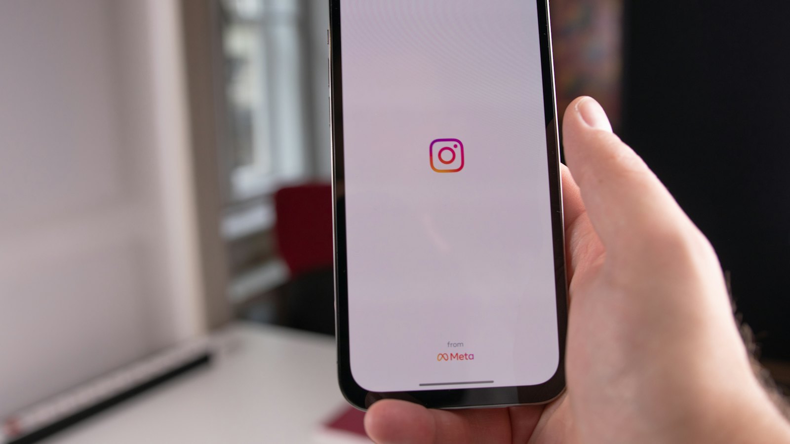 Ruka drži telefon sa otvorenim Instagramom