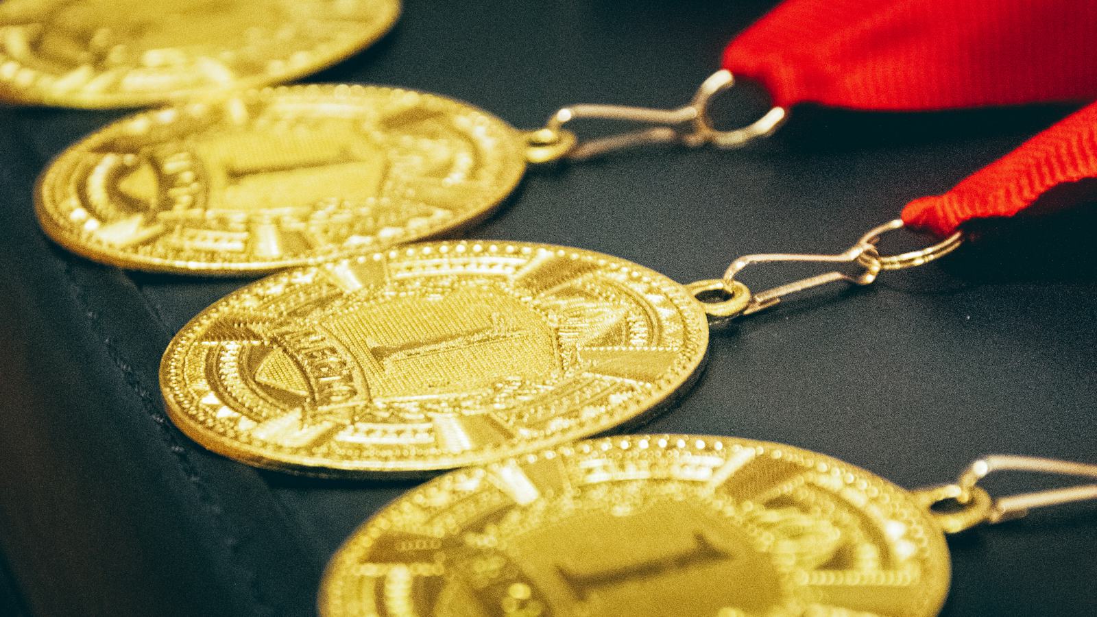 Niz zlatnih medalja sa crvenom trakom
