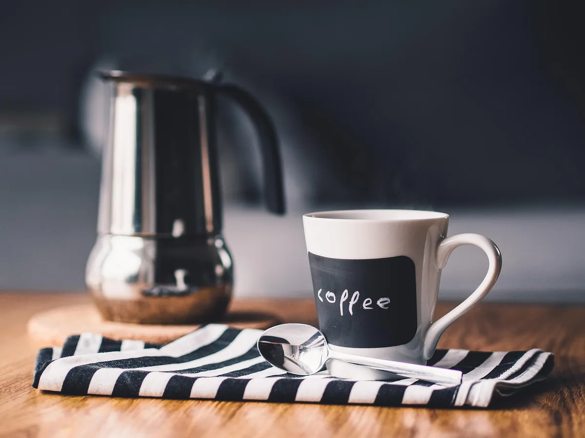 Šolja tople kafe na kuhinjskom stolu